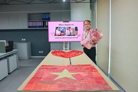 Chinoros Benjachavakul, a Thai man who is working in Vietnam, and his blood donation certificates arranged into a Vietnamese flag. Photo: Supplied