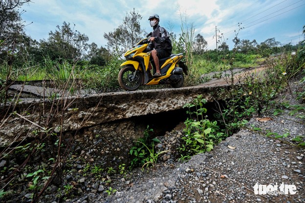 A resident travels on the road while it has yet to finish and has deteriorated. Photo: M.V. / Tuoi Tre