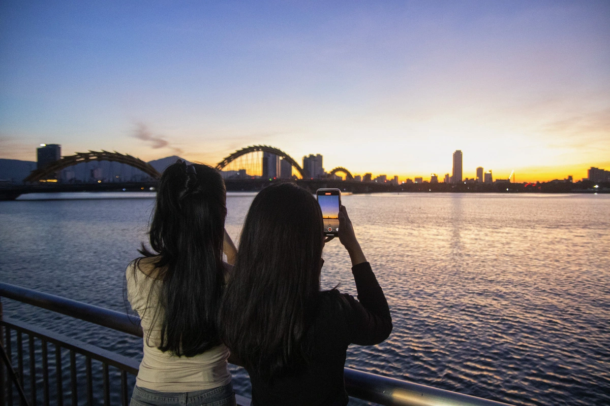 Many young people capture the moment as they watch the sunrise over the Han River in Da Nang, central Vietnam. Photo: Thanh Nguyen / Tuoi Tre