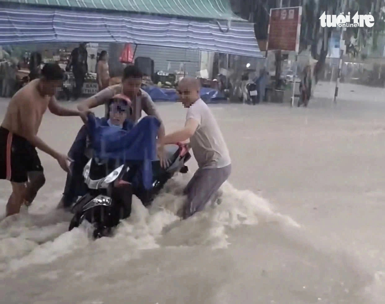 Several men rescue a motorcyclist from floodwaters in Ben Cat City under Binh Duong Province, southern Vietnam on August 26, 2024. Photo: B.D.