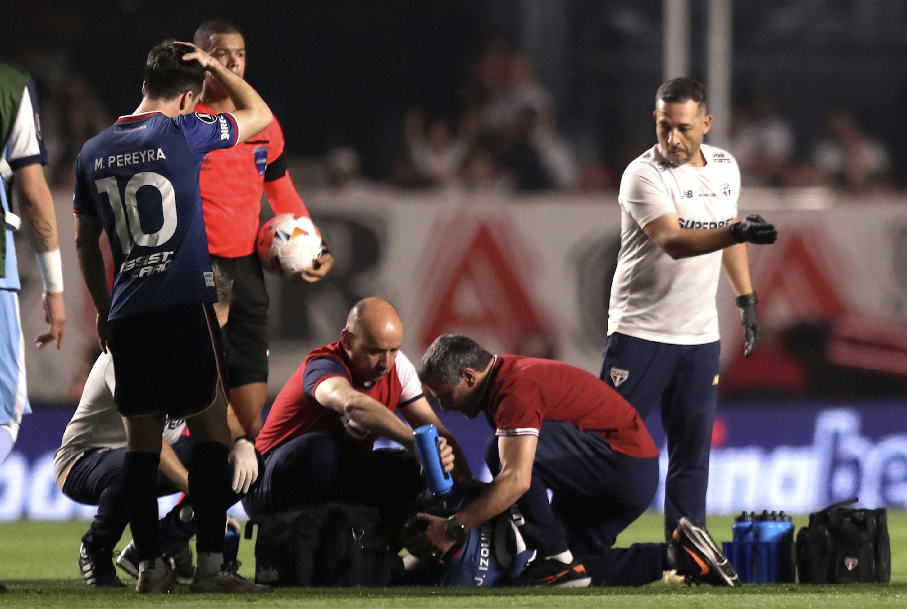 Soccer Football - Copa Libertadores - Round of 16 - Second Leg - Sao Paulo v Nacional - Estadio Morumbi, Sao Paulo, Brazil - August 22, 2024 Nacional's Juan Izquierdo receives medical attention after sustaining an injury. Photo: Reuters