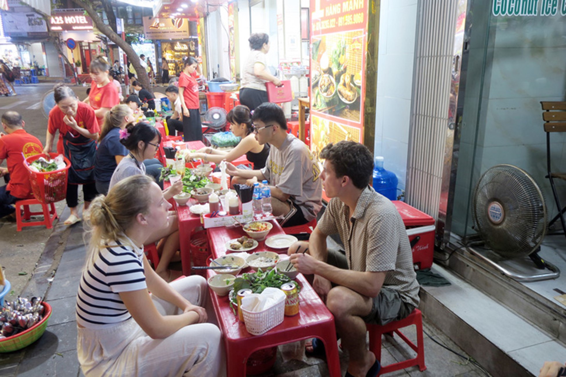 Tourists at a ‘bun cha’ (rice noodles with grilled pork and meatballs) eatery in Hanoi. Photo: T.T.D. / Tuoi Tre