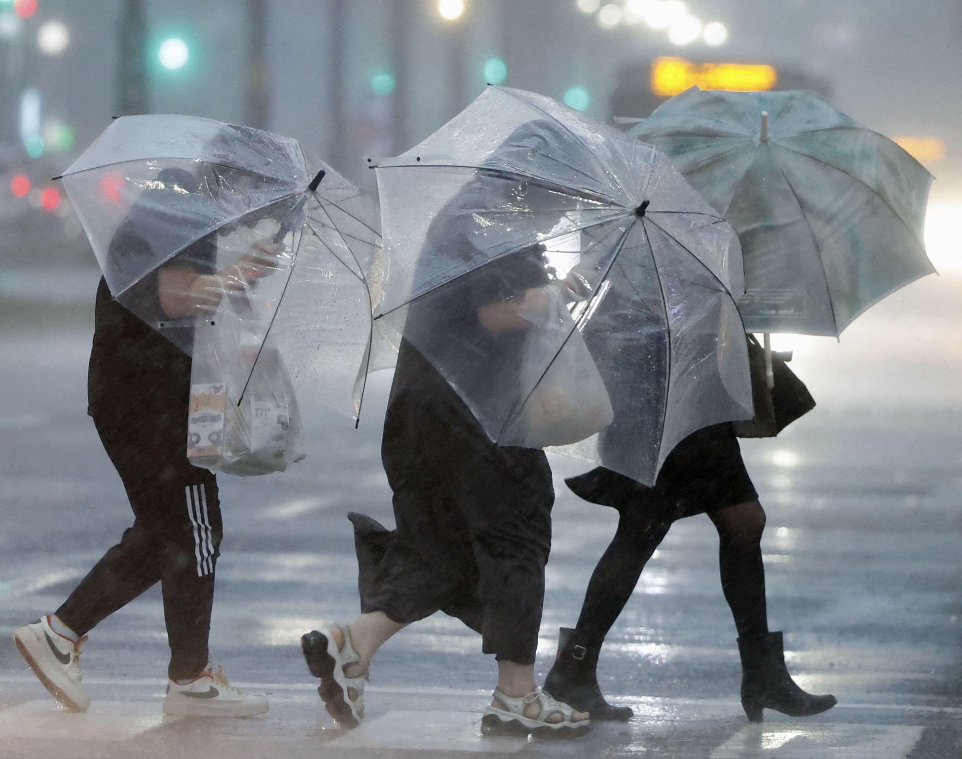 Pedestrians holding umbrellas struggle against strong wind and heavy rains caused by Typhoon Shanshan in Kagoshima, southwestern Japan August 28, 2024.