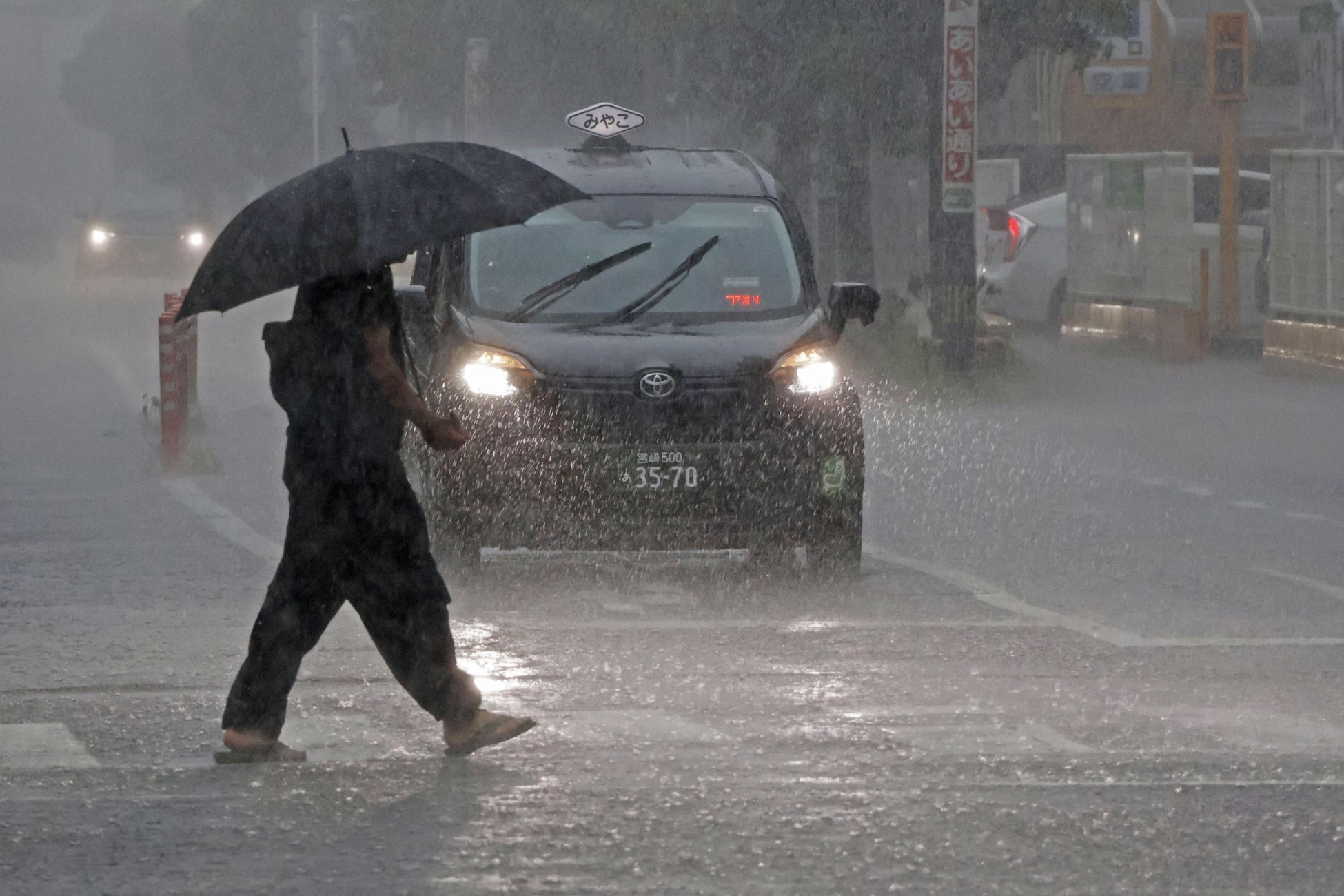 A passerby holding an umbrella walks in heavy rains caused by Typhoon Shanshan in Miyazaki, southwestern Japan August 28, 2024.