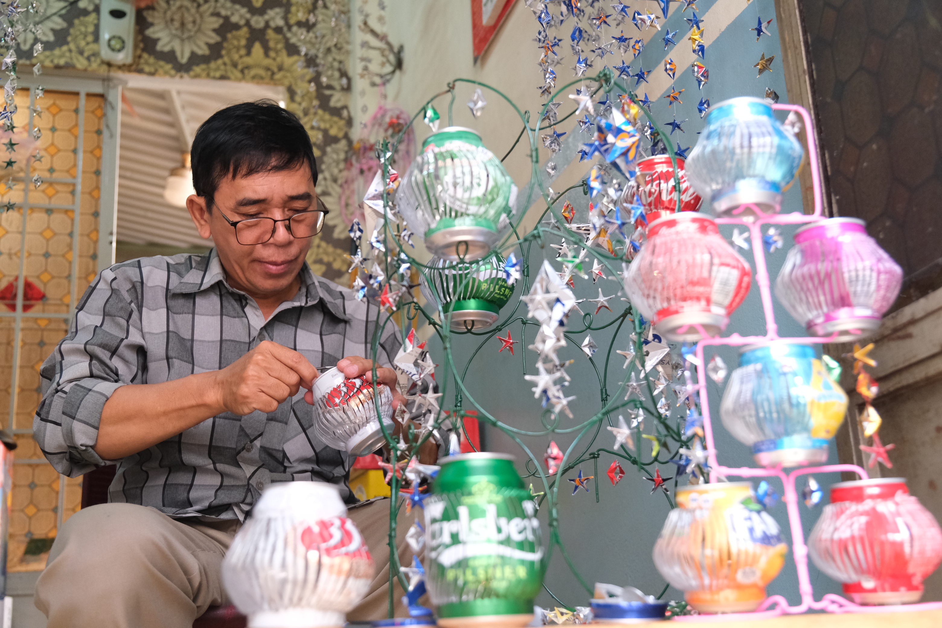 Nguyen Van Tuan crafts beverage cans into colorful lanterns. Photo: Ngoc Phuong / Tuoi Tre News