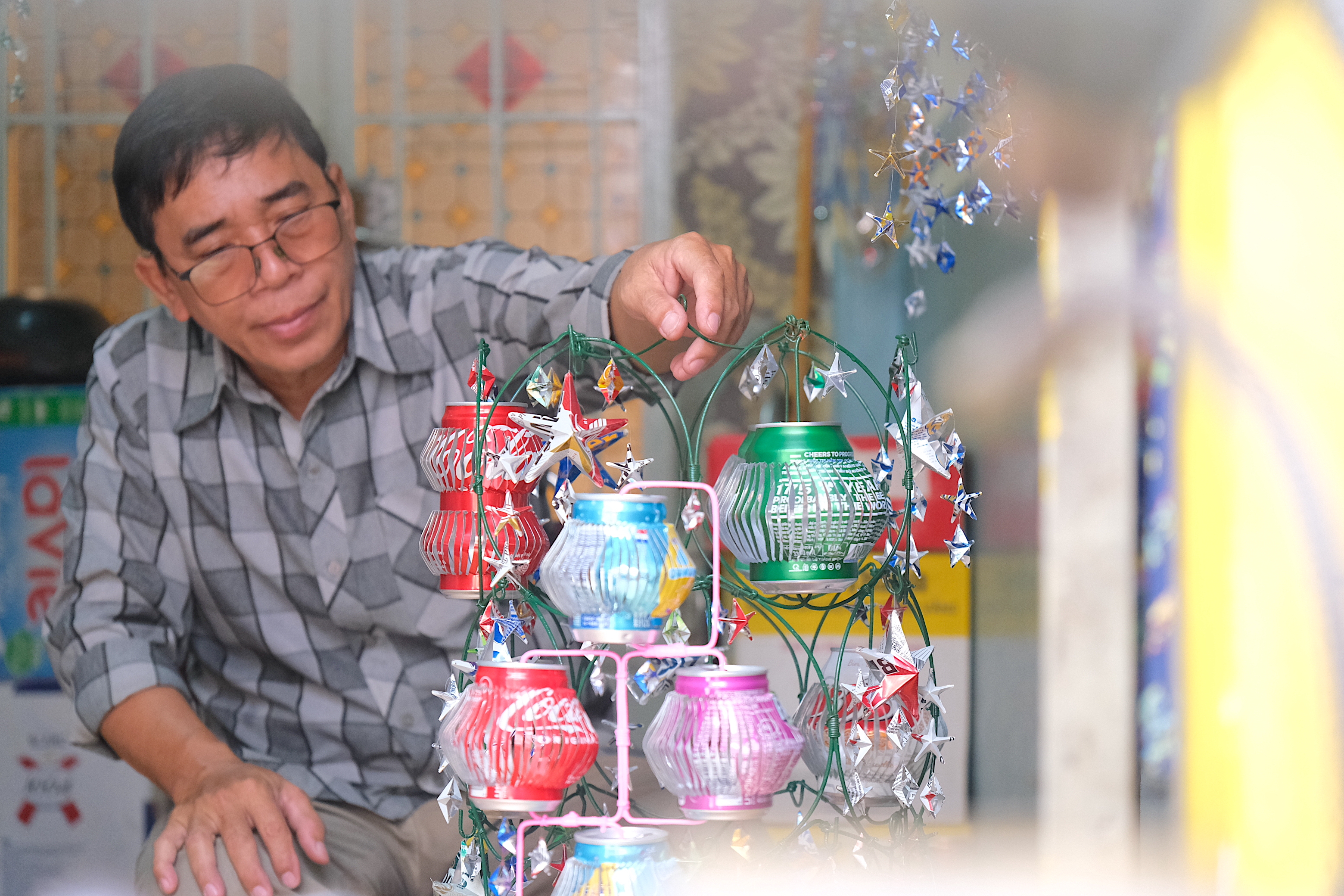 Tuan is seen in this photo with lanterns he crafts from discarded cans. Photo: Ngoc Phuong / Tuoi Tre News