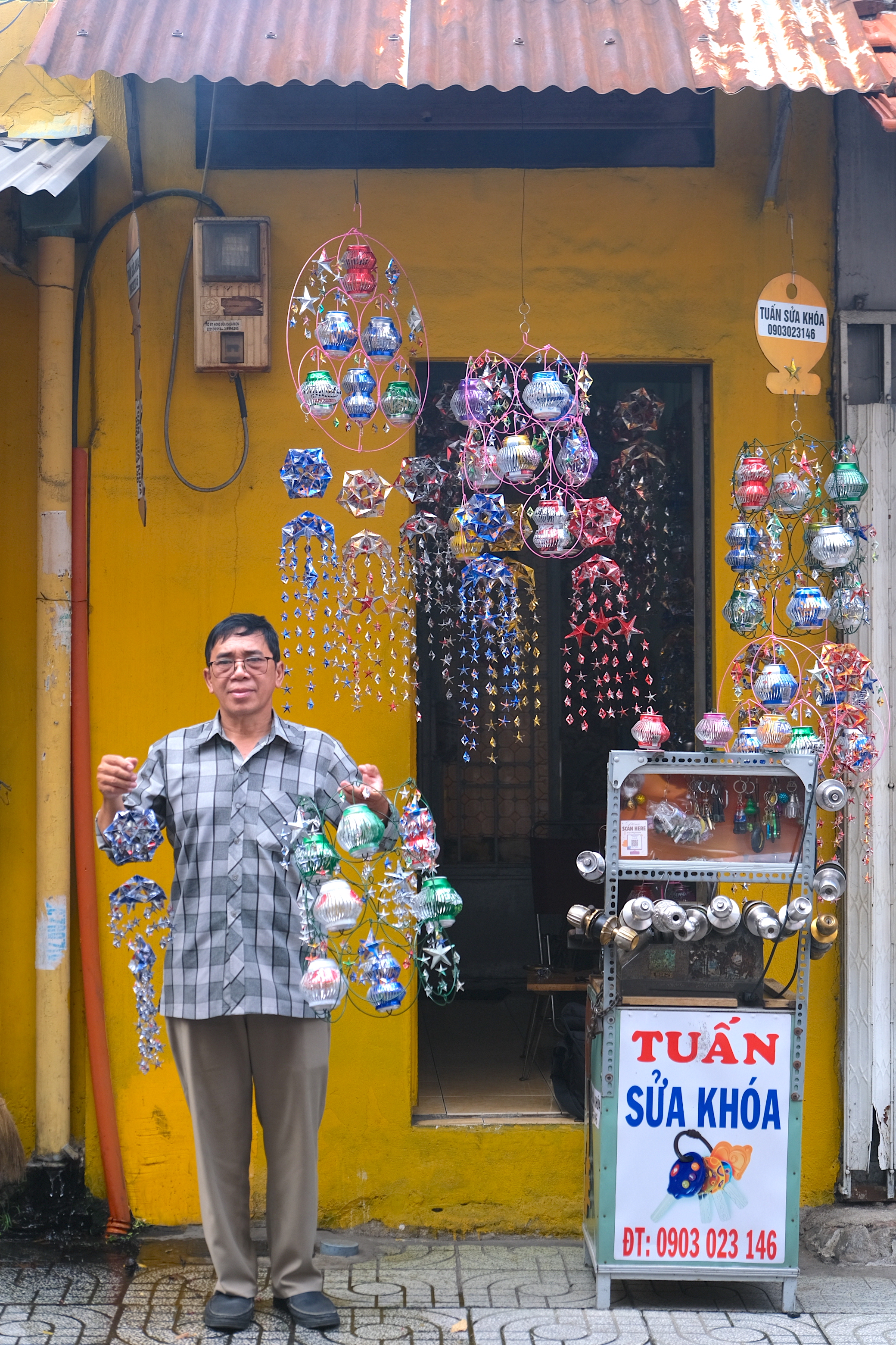 Tuan shows off his lanterns as he poses for a photo at his locksmith shop in District 1, Ho Chi Minh City. Photo: Ngoc Phuong / Tuoi Tre News