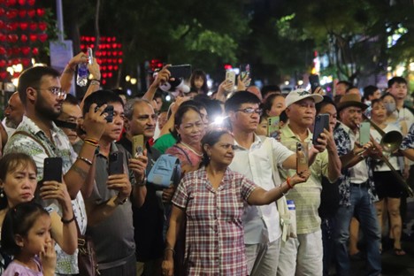 Tourists use mobile phones to record vibrant dances. Photo: Thanh Nguyen / Tuoi Tre