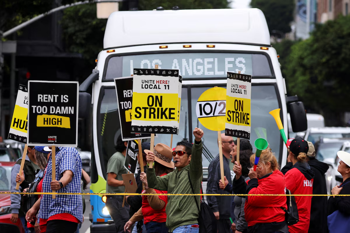 Hotel workers march and protest, while a bus driver waits to cross the road, as they continue their strike in Los Angeles, California, U.S., October 25, 2023. Photo: Reuters