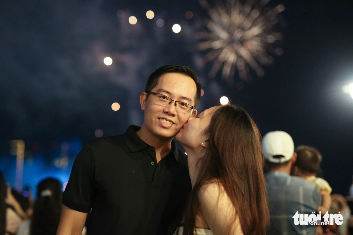 A young girl kisses her boyfriend amid a crowd watching a fireworks show in Ho Chi Minh City on September 2, 2024 to welcome Vietnam’s 79th National Day. Photo: Phuong Quyen / Tuoi Tre