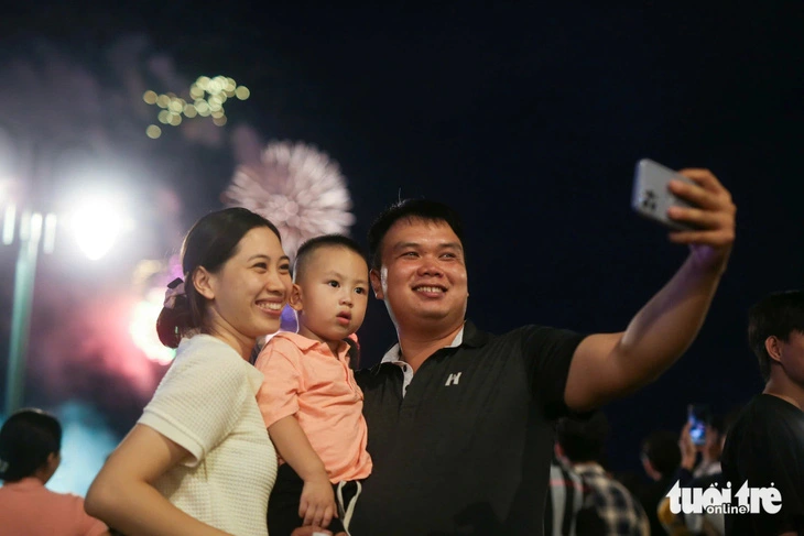 A man takes a wefie with his family while enjoying a fireworks display in Ho Chi Minh City on September 2, 2024 in celebration of Vietnam’s 79th National Day. Photo: Phuong Quyen / Tuoi Tre