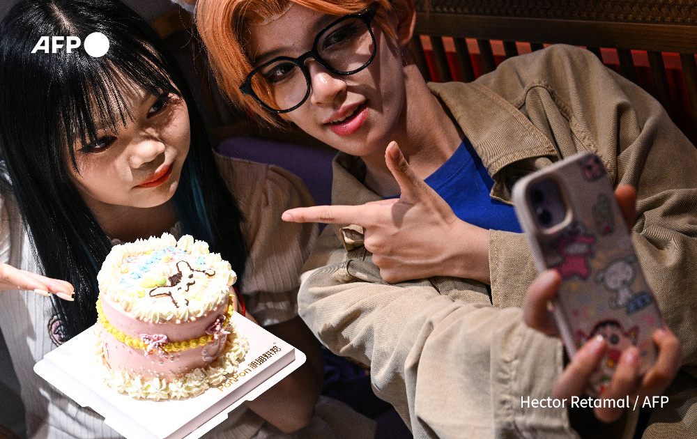 This photo taken on August 14, 2024 shows cosplayer Xu Yunting (R), dressed as Jesse, a male character from the video game 'Light and Night', and Feng Xinyu posing for a selfie at a restaurant during their 'cos commissioning' date in Shanghai. Photo: AFP