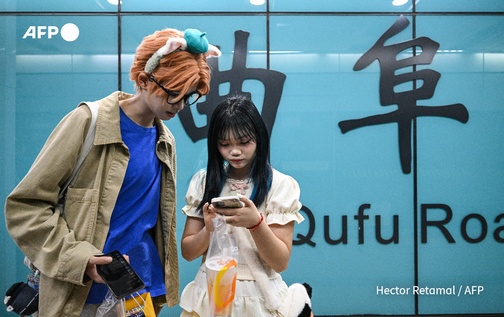 In this photo taken on August 14, 2024, cosplayer Xu Yunting (L), dressed as Jesse, a male character from the video game 'Light and Night', and Feng Xinyu are seen at a metro station during their 'cos commissioning' date in Shanghai. Photo: AFP