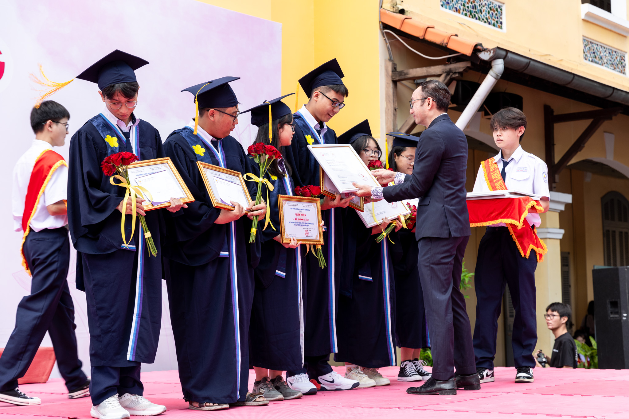 A representative of DOL English presents scholarships to students at Nguyen Thi Minh Khai High School in District 3, Ho Chi Minh City, September 5, 2024.