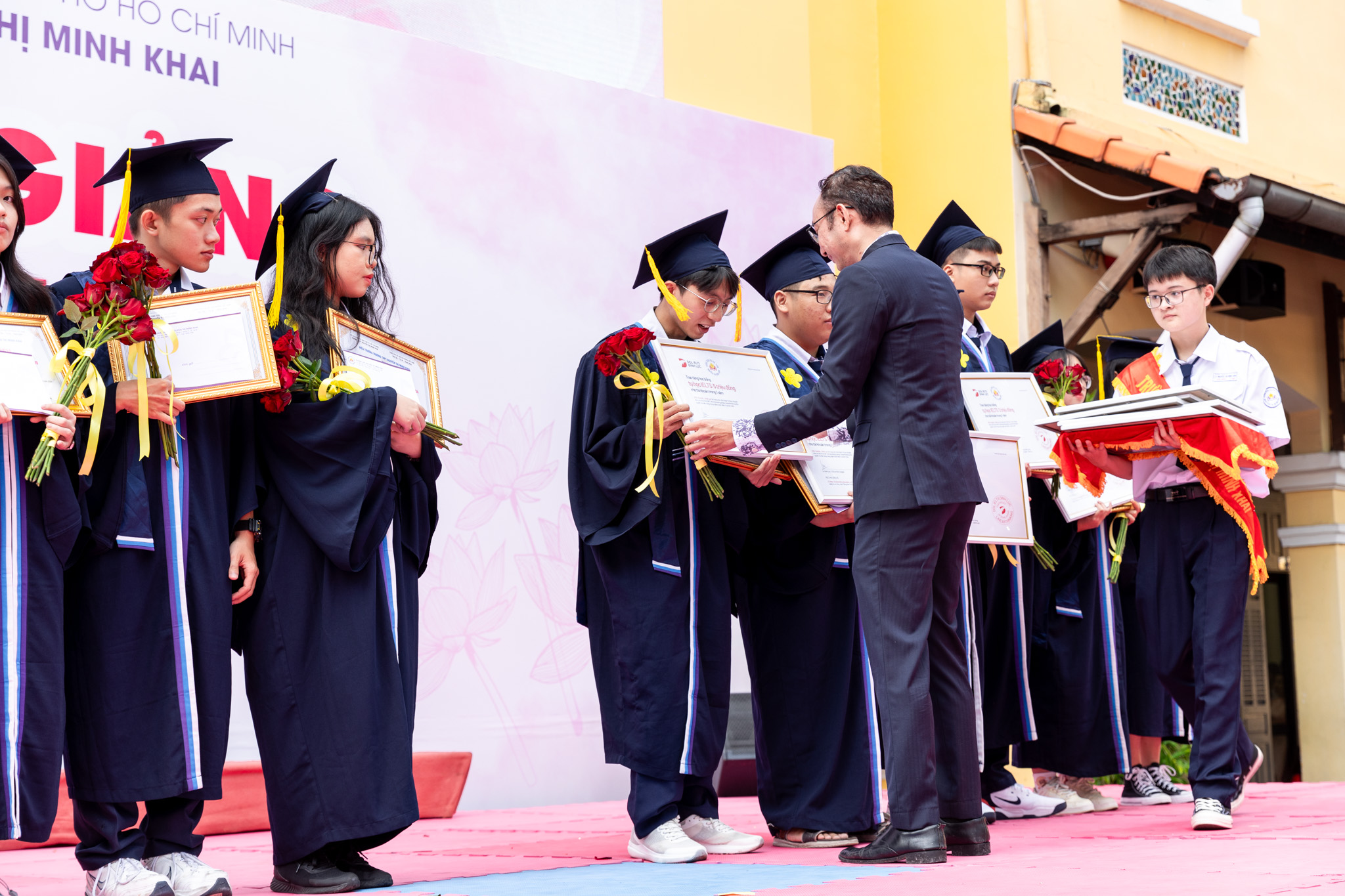 A representative of DOL English presents scholarships to students at Nguyen Thi Minh Khai High School in District 3, Ho Chi Minh City, September 5, 2024.