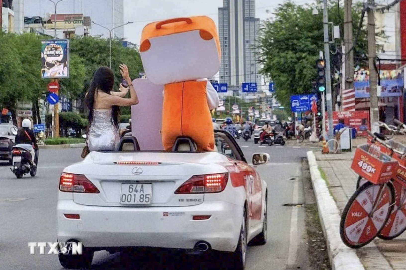 Lexus driver faces penalty for allowing passenger to sit on car door in Vietnam