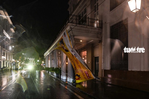 Strong winds cause a billboard on Trang Tien Street in Hanoi to collapse. Photo: Hong Quang / Tuoi Tre