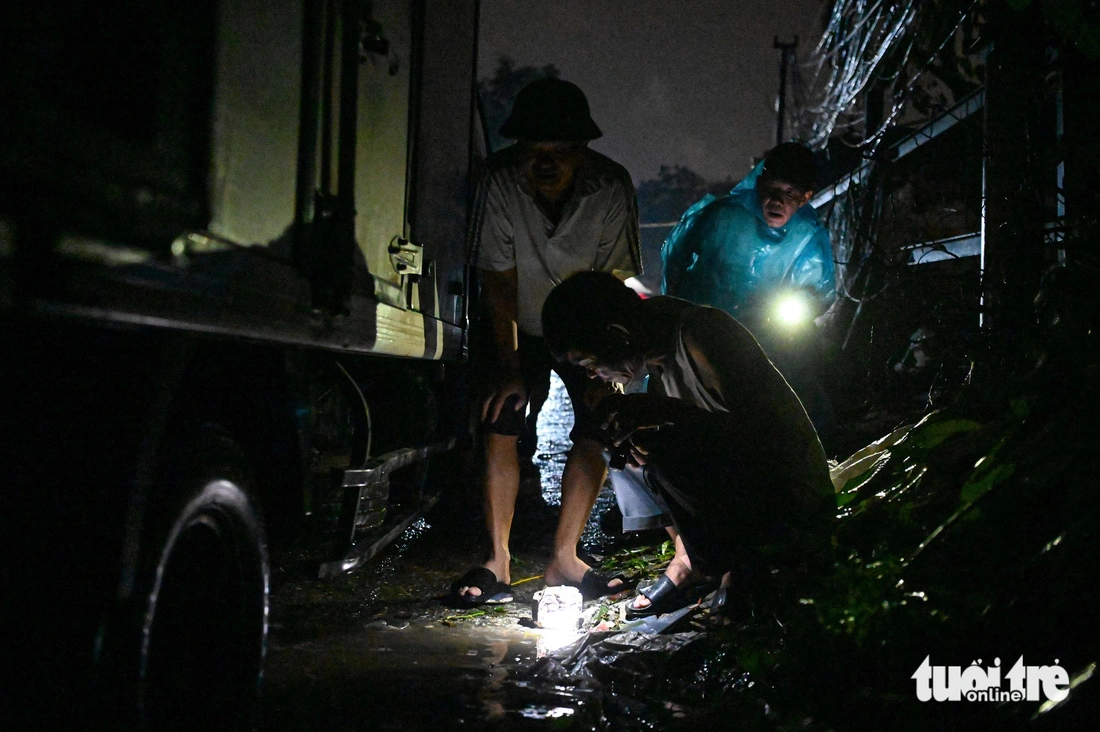 Residents use stones to check the floodwater level, saying that the water level rose eight centimeters per hour. Photo: Hong Quang / Tuoi Tre