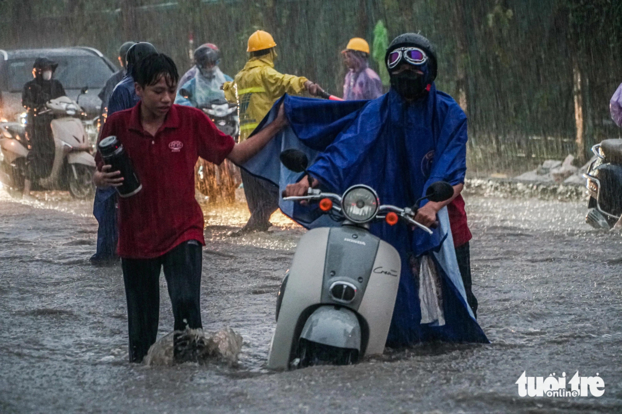 Motorcyclists attempt to pass through a heavily-flooded road after work in Hanoi, September 9, 2024. Photo: Pham Tuan / Tuoi Tre