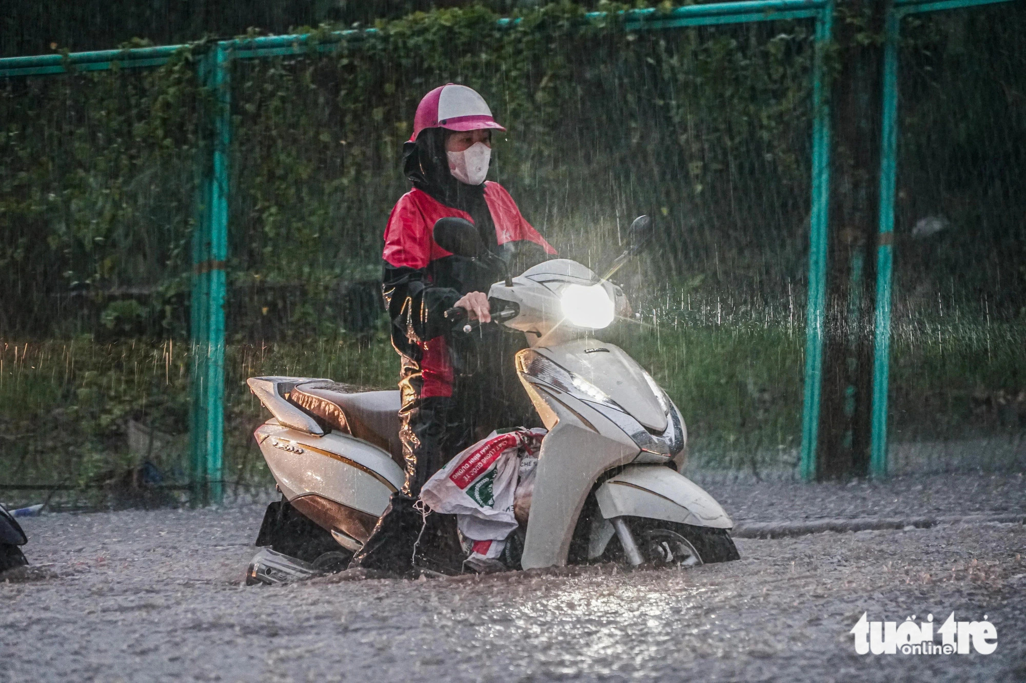 Motorcyclists struggled to wade through a flooded road in Hanoi, September 9, 2024. Photo: Pham Tuan / Tuoi Tre