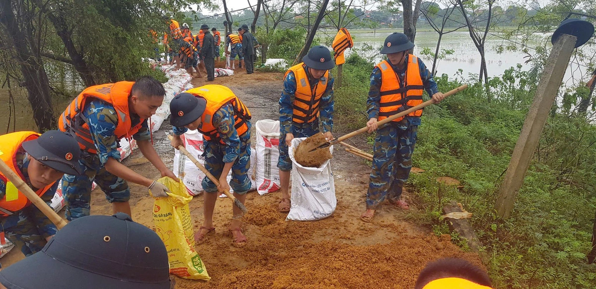 Military officers and soldiers help reinforce a dyke in Dong Son Commune, Chuong My District, Hanoi, northern Vietnam, in response to the swift rise of the Red River. Photo: Military unit