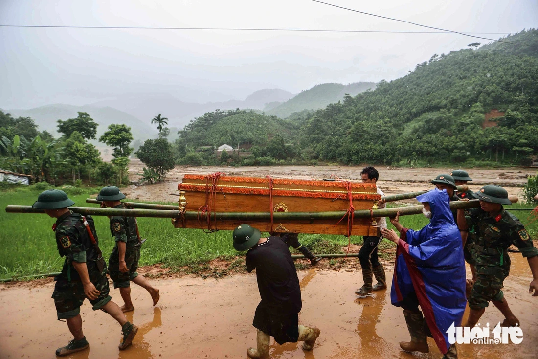 Military officers carry a deceased victim of the flash flood in Lao Cai Province. Photo: Nguyen Khanh / Tuoi Tre