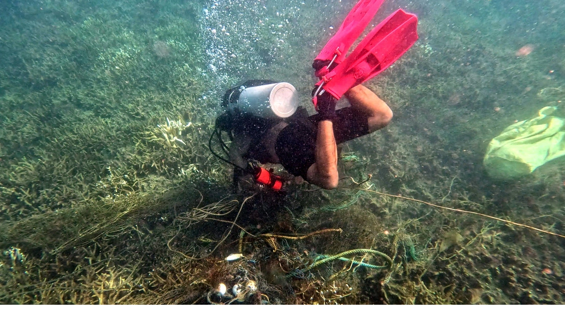 A scuba diver cuts a fishing net from a coral reef off Con Dao Island, Ba Ria - Vung Tau Province. Photo: Supplied