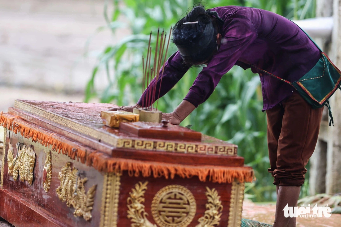 A woman collapses next to the coffin of a family member. Photo: Nguyen Khanh / Tuoi Tre