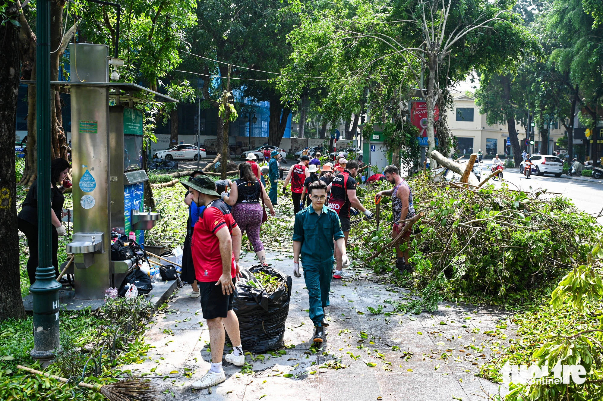 Foreigners help clear fallen tree branches on the street in Hoan Kiem District, Hanoi, September 14, 2024. Photo: Hong Quang / Tuoi Tre