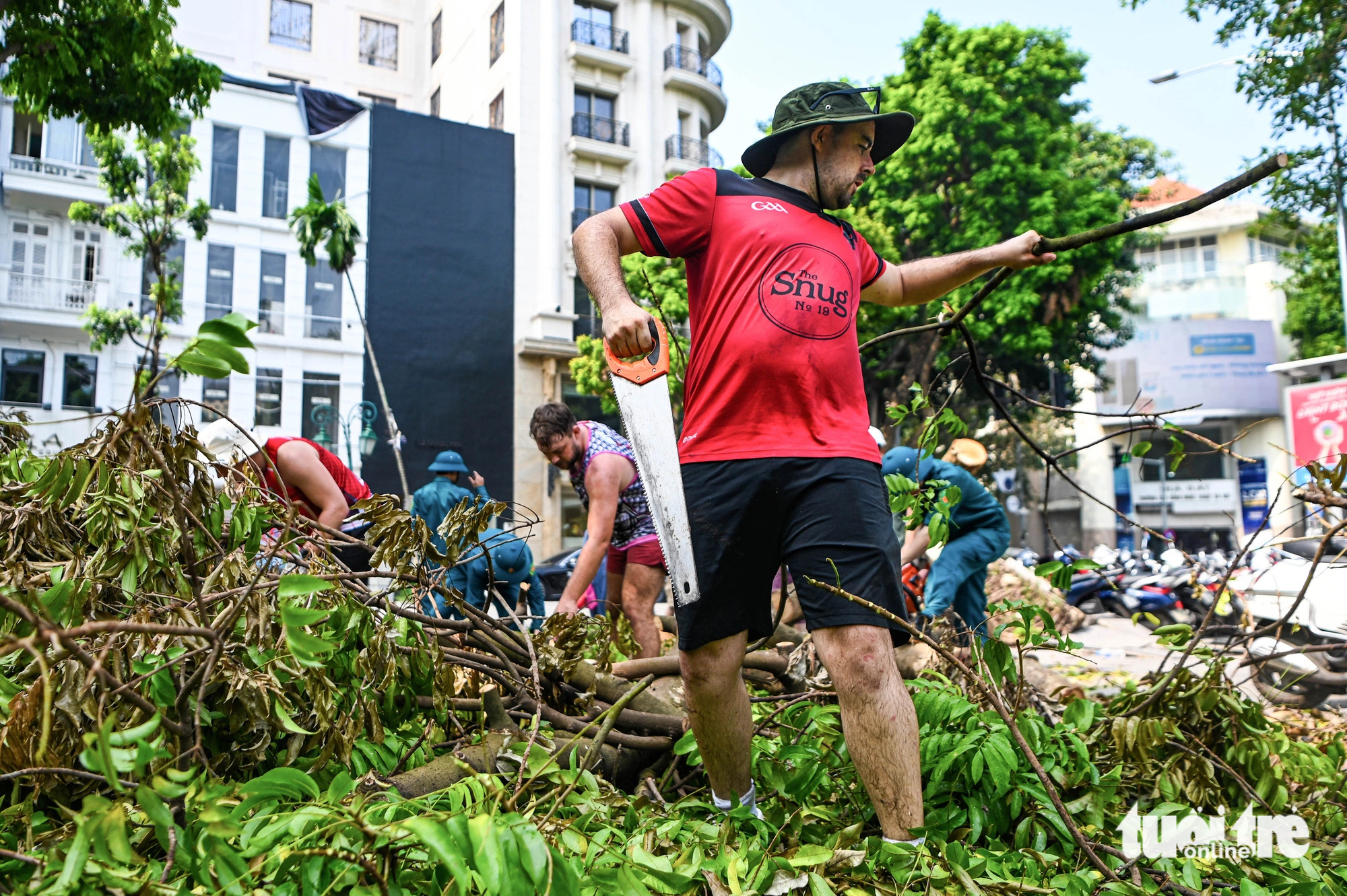 Foreigners help clear fallen tree branches on the street in Hoan Kiem District, Hanoi, September 14, 2024. Photo: Hong Quang / Tuoi Tre