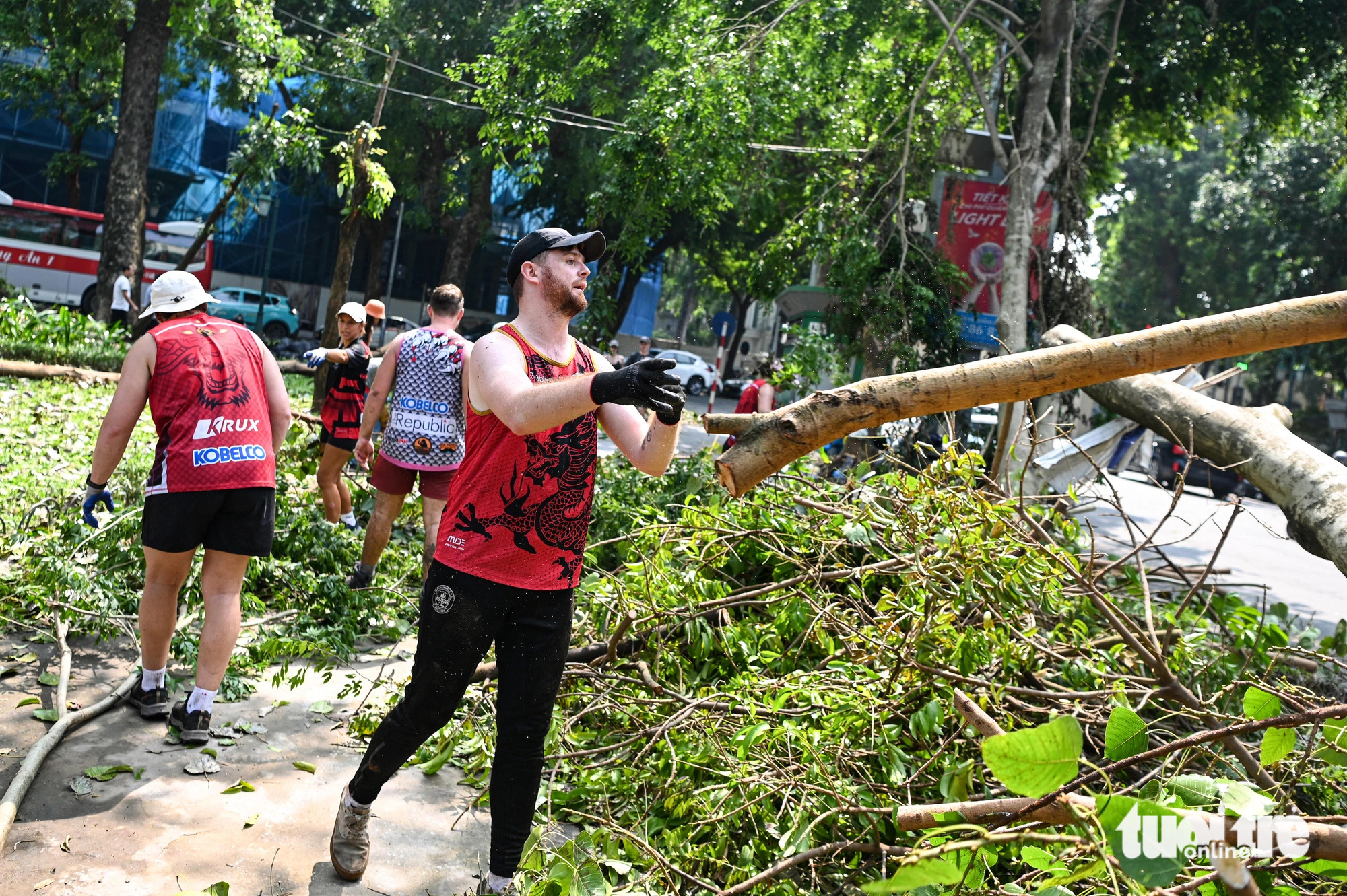 Foreigners help clear fallen tree branches on the street in Hoan Kiem District, Hanoi, September 14, 2024. Photo: Hong Quang / Tuoi Tre