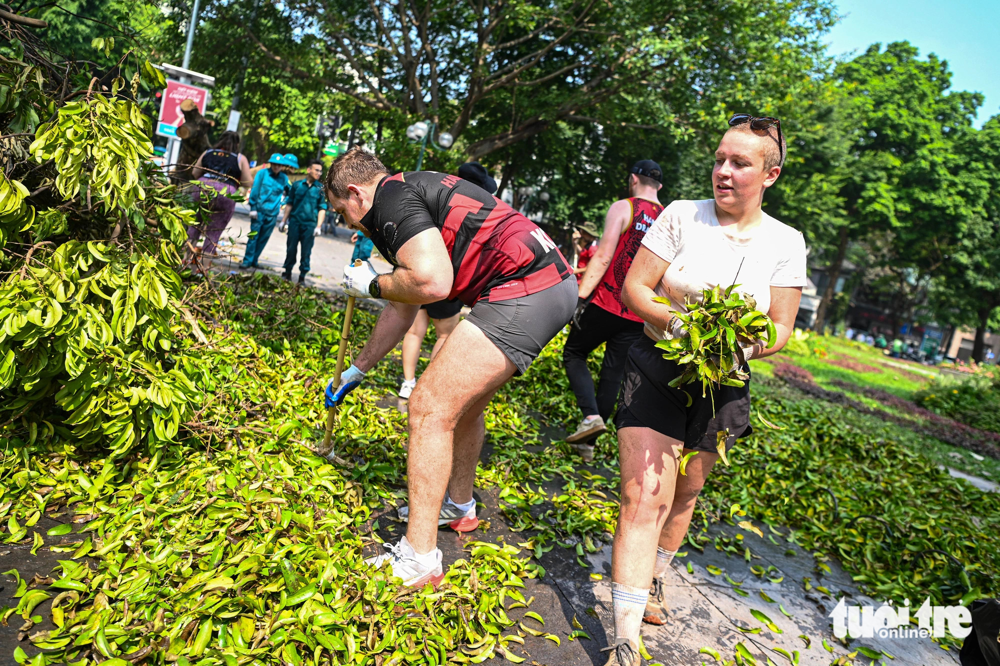 Foreigners help clear fallen tree branches on the street in Hoan Kiem District, Hanoi, September 14, 2024. Photo: Hong Quang / Tuoi Tre