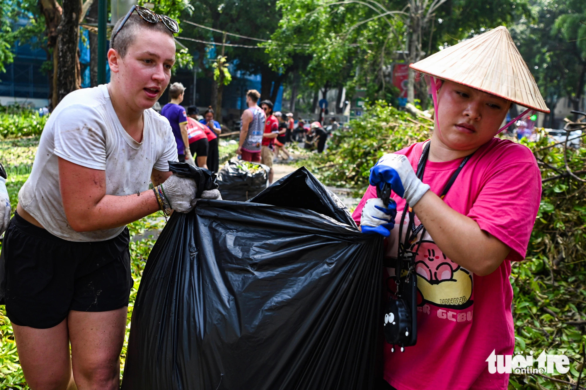 Foreigners help clear fallen tree branches on the street in Hoan Kiem District, Hanoi, September 14, 2024. Photo: Hong Quang / Tuoi Tre