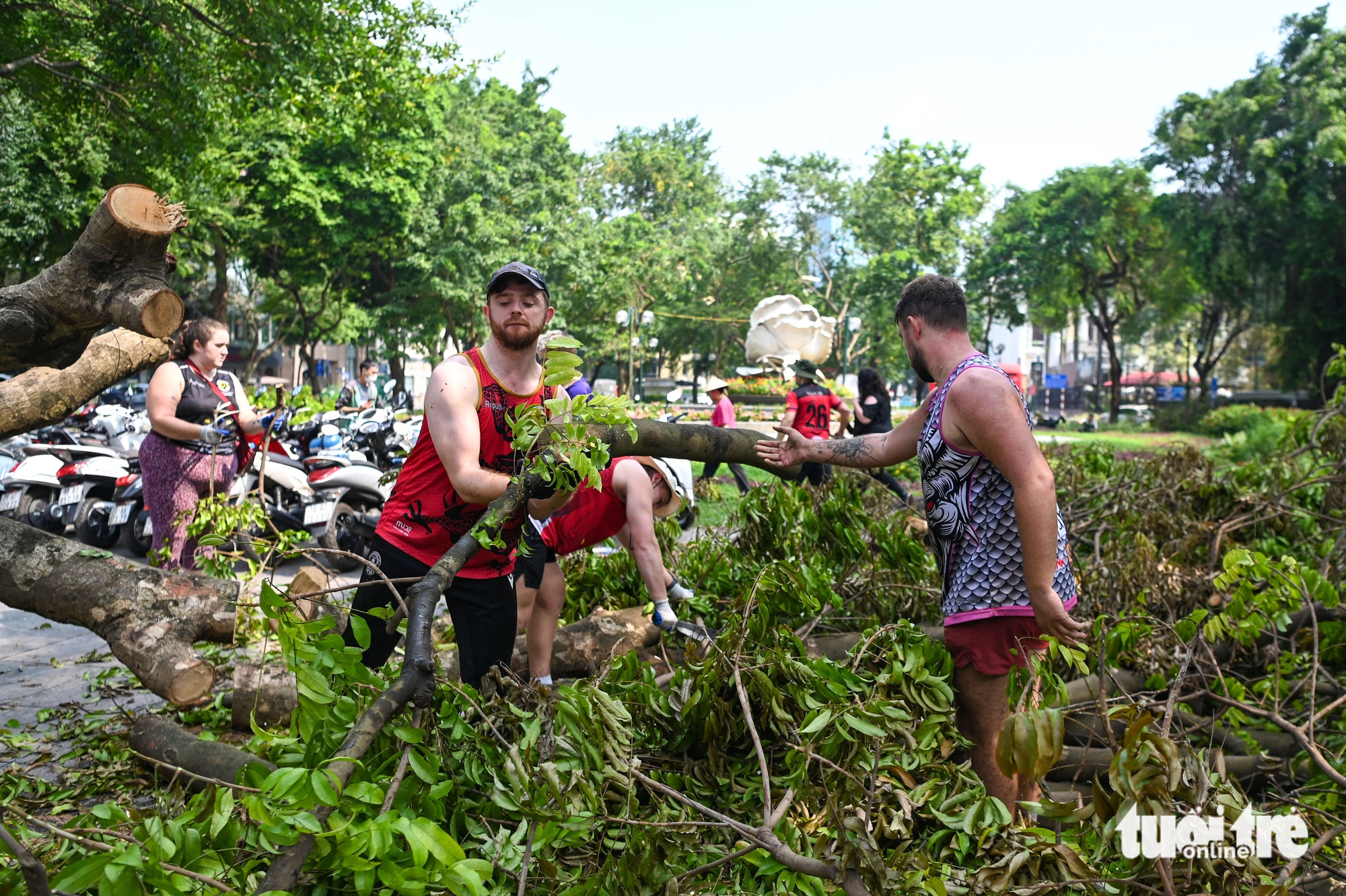 Foreigners help clear fallen tree branches on the street in Hoan Kiem District, Hanoi, September 14, 2024. Photo: Hong Quang / Tuoi Tre