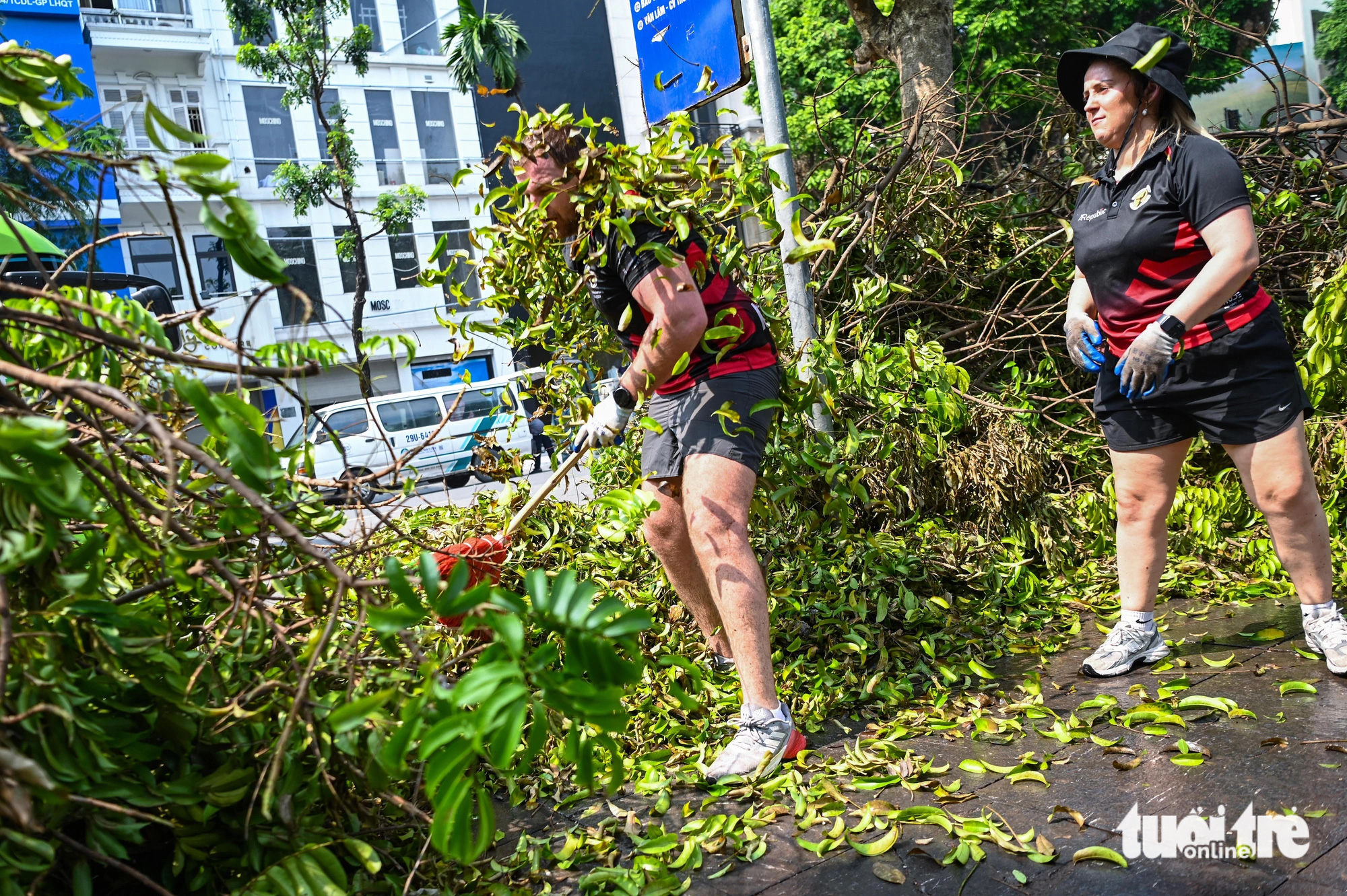 Foreigners help clear fallen tree branches on the street in Hoan Kiem District, Hanoi, September 14, 2024. Photo: Hong Quang / Tuoi Tre