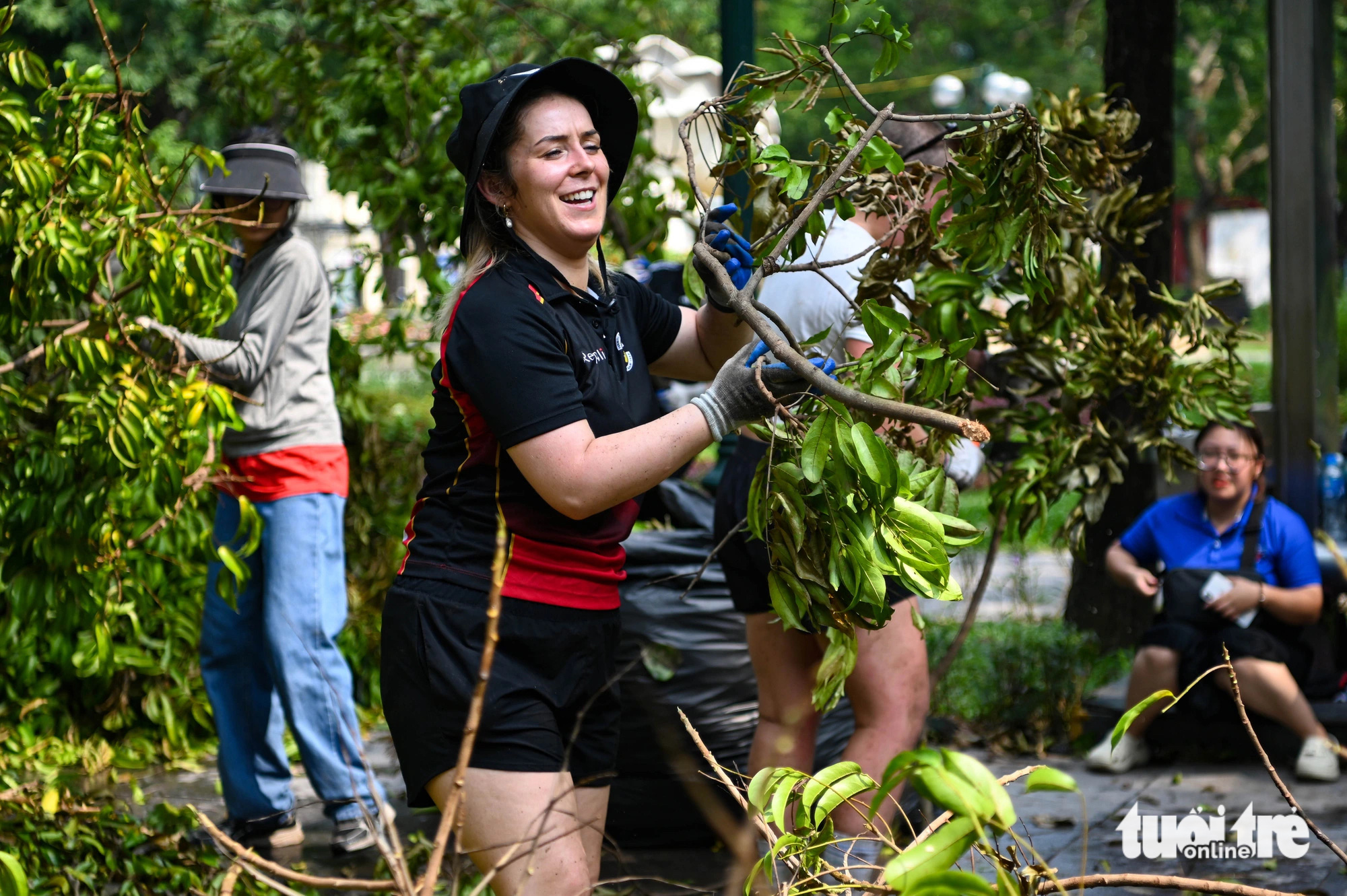 A foreigner helps clear fallen tree branches on the street in Hoan Kiem District, Hanoi, September 14, 2024. Photo: Hong Quang / Tuoi Tre