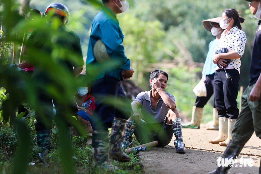 Thoi and those losing his family members to the flood. Photo: Nguyen Khanh / Tuoi Tre