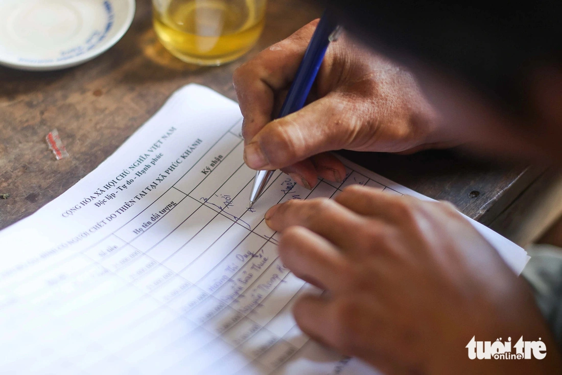 He signed to receive aid for four family members. Photo: Nguyen Khanh / Tuoi Tre