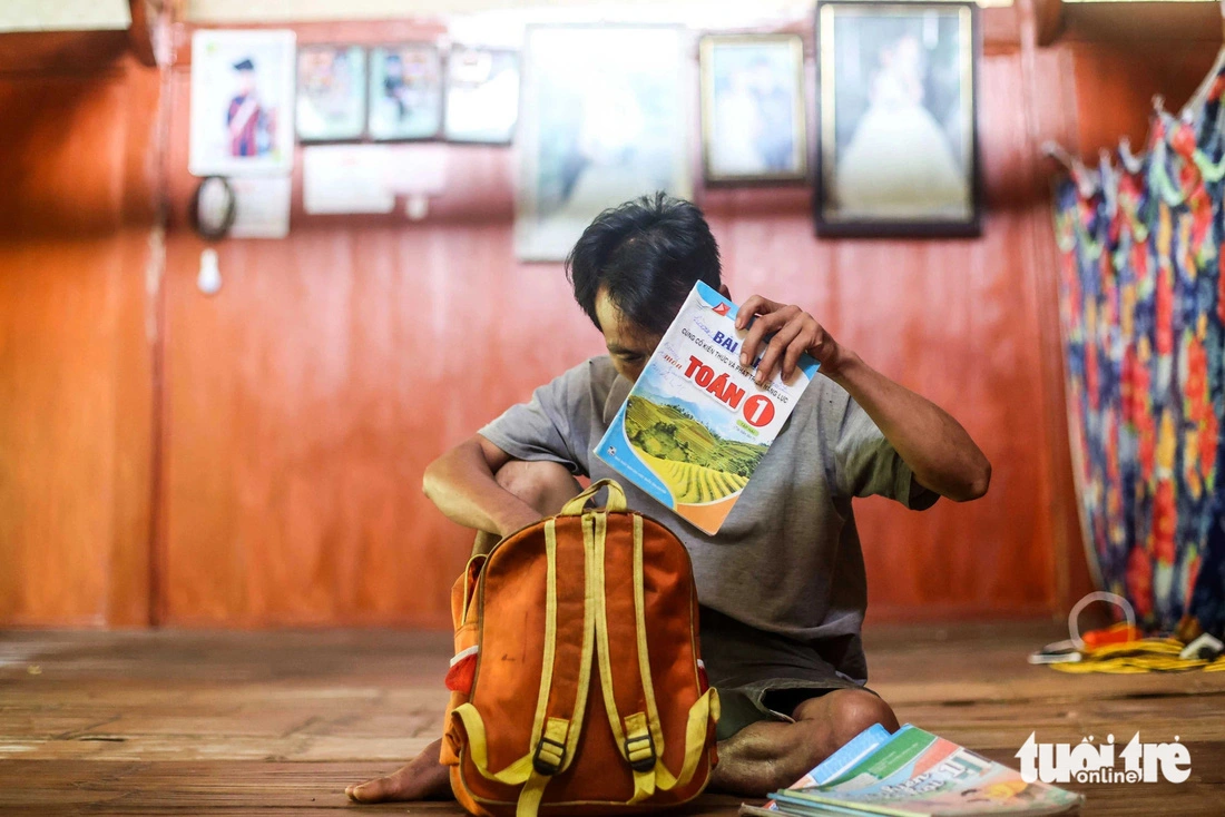 Thoi opens his first-born daughter’s backpack and takes out books, which are now mementos of his daughter. Photo: Nguyen Khanh / Tuoi Tre