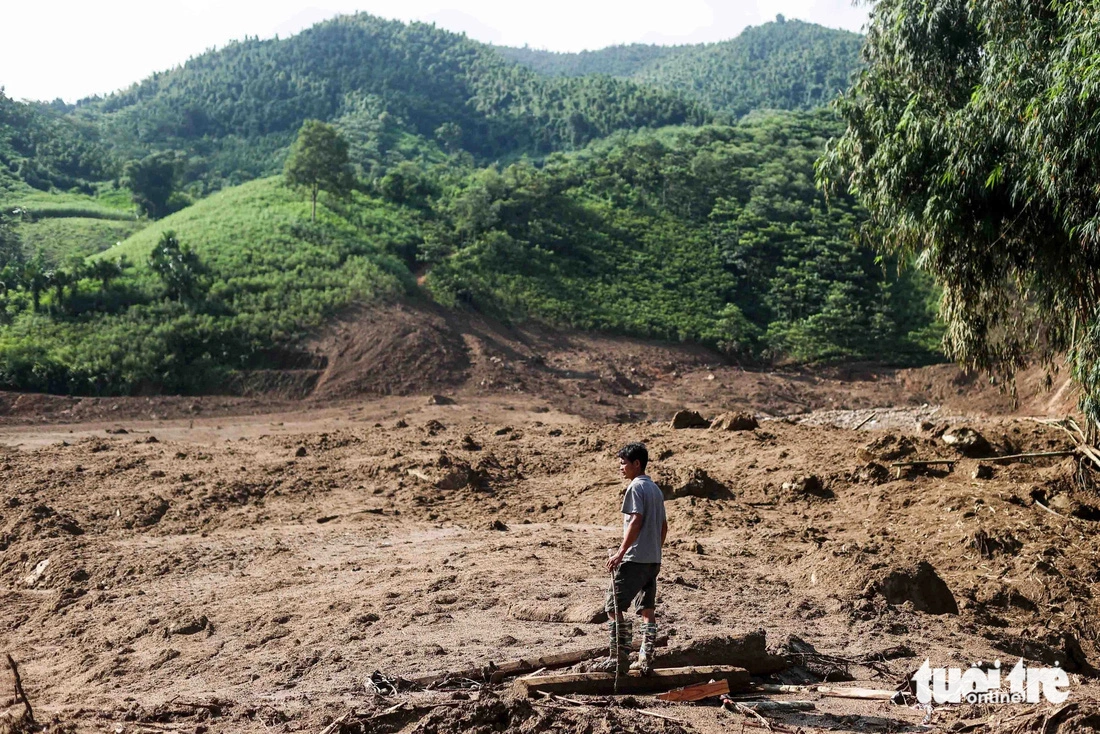 Thoi stands in the flood-hit area. His village was nearly destroyed with houses brought down and buried in mud. Photo: Nguyen Khanh / Tuoi Tre