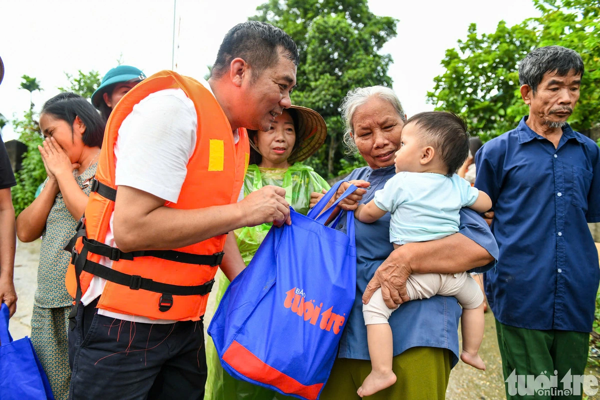 A residents in a flooded area in Yen Binh District, Yen Bai Province, northern Vietnam receive a gift set contributed by Tuoi Tre readers. Photo: Nam Tran / Tuoi Tre