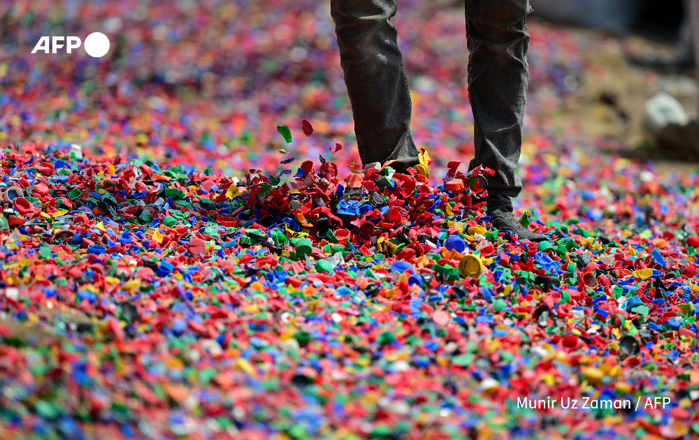 A worker dries plastic chips for recycling in Dhaka on September 8, 2024. Photo: AFP