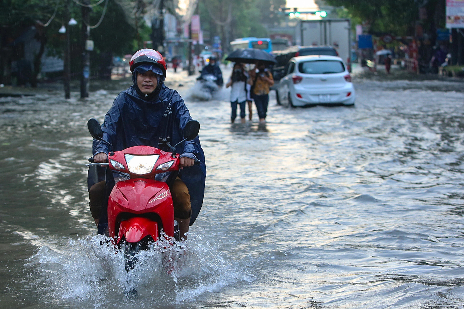 Motorcyclists struggle to wade through a waterlogged road section in Hanoi, September 16, 2024. Photo: Hong Quang / Tuoi Tre