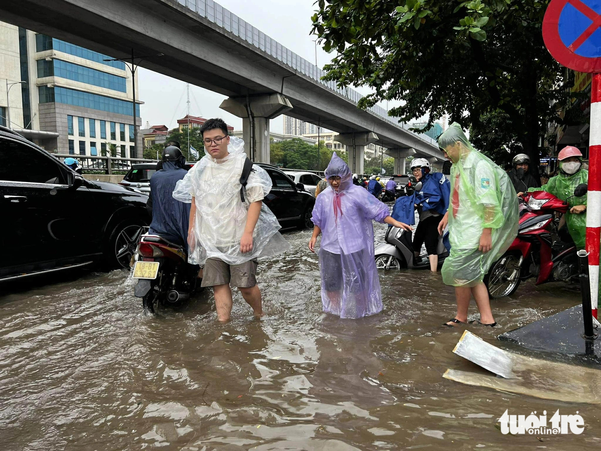 Students are seen wading through floodwaters on Nguyen Trai Street to get to school, Hanoi, September 16, 2024. Photo: Nam Tran / Tuoi Tre