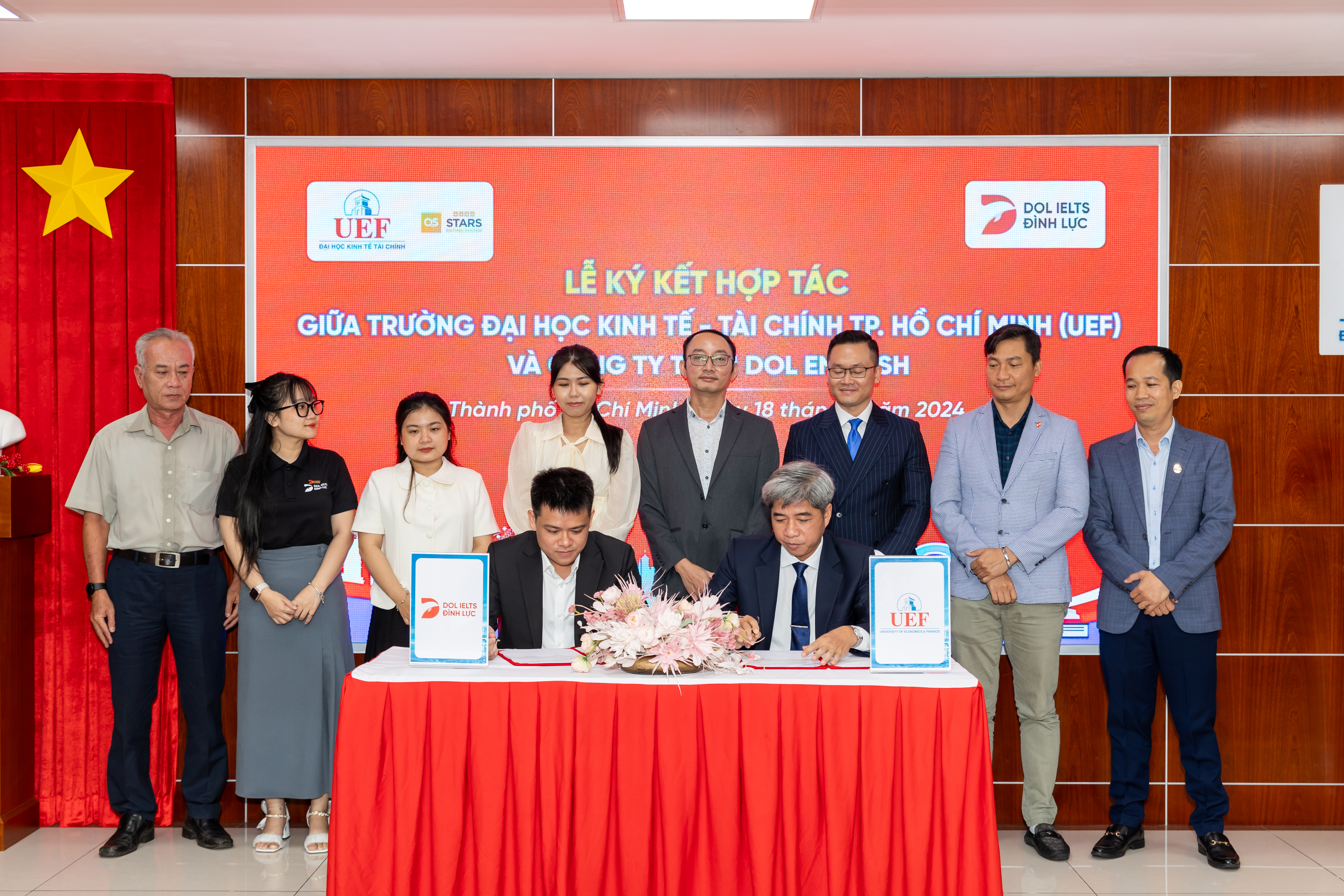 Le Dinh Luc (sitting, left), founder and CEO of DOL English, and Dr. Nguyen Thanh Giang, president of the Ho Chi Minh City University of Economics and Finance, sign a partnership agreement between the two institutions in Ho Chi Minh City, September 18, 2024.