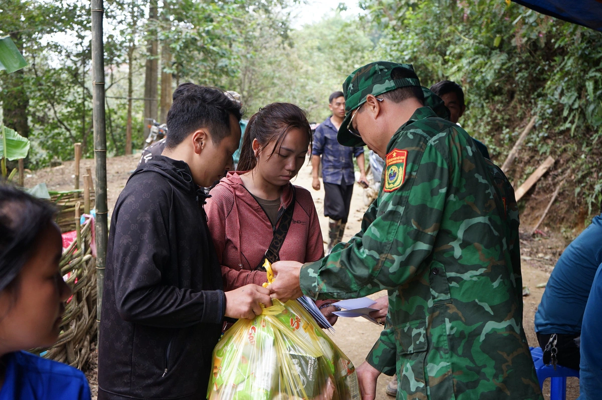 Sung A Giang and his wife receive support from neighbors and border guards in Lao Cai Province. Photo: Vu Tuan / Tuoi Tre