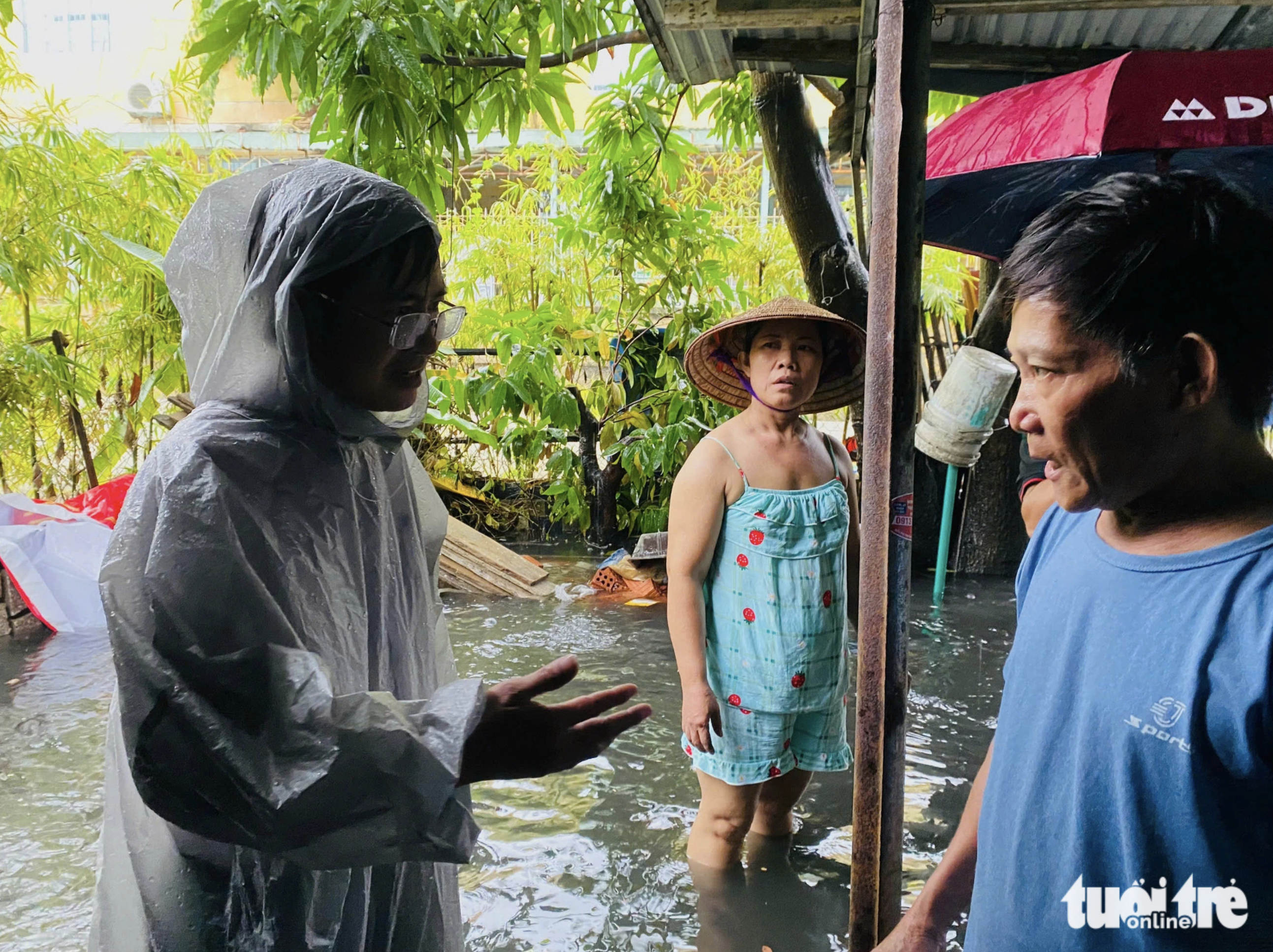 Nguyen Van Huu (L), vice-chairman of An Hai Tay Ward People’s Committee, visits a flood-hit household. Photo: Doan Nhan / Tuoi Tre