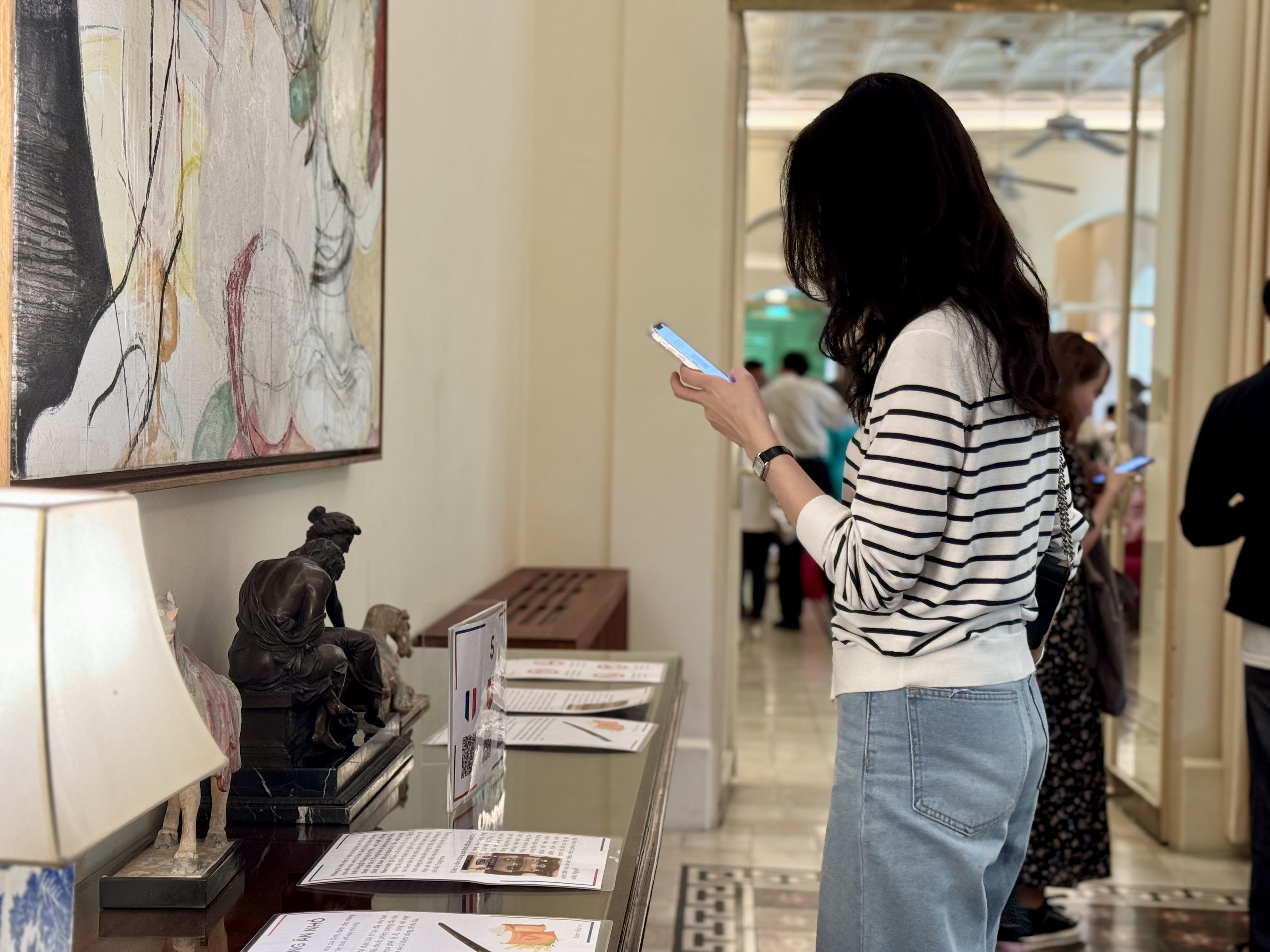 A visitor scans QR codes to read information about areas in the French Residence. Photo: Minh Khoi / Tuoi Tre News