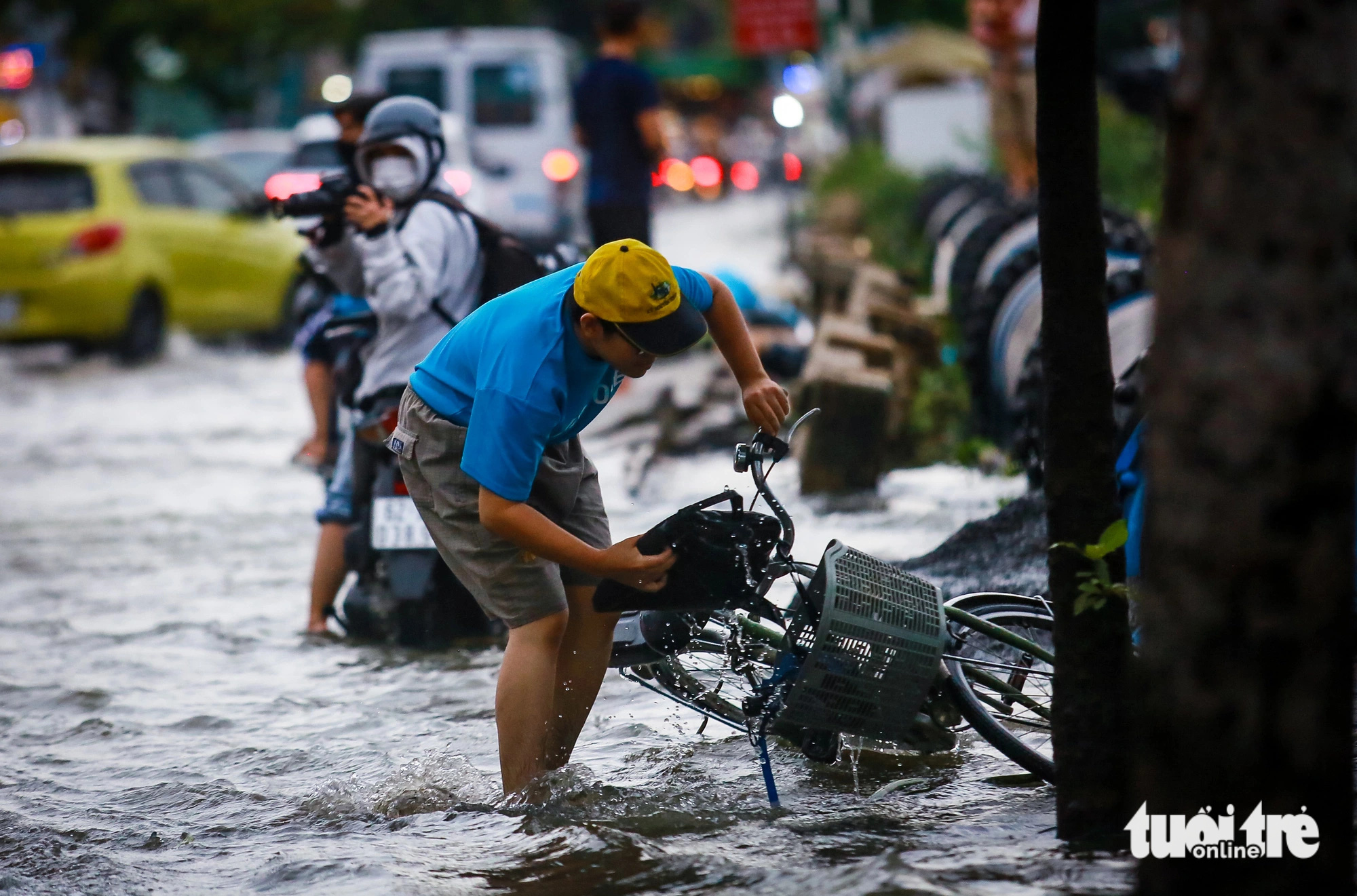 A cyclist falls off their bike due to a pothole during high tides on Tran Xuan Soan Street in District 7, Ho Chi Minh City, September 20, 2024. Photo: Chau Tuan / Tuoi Tre