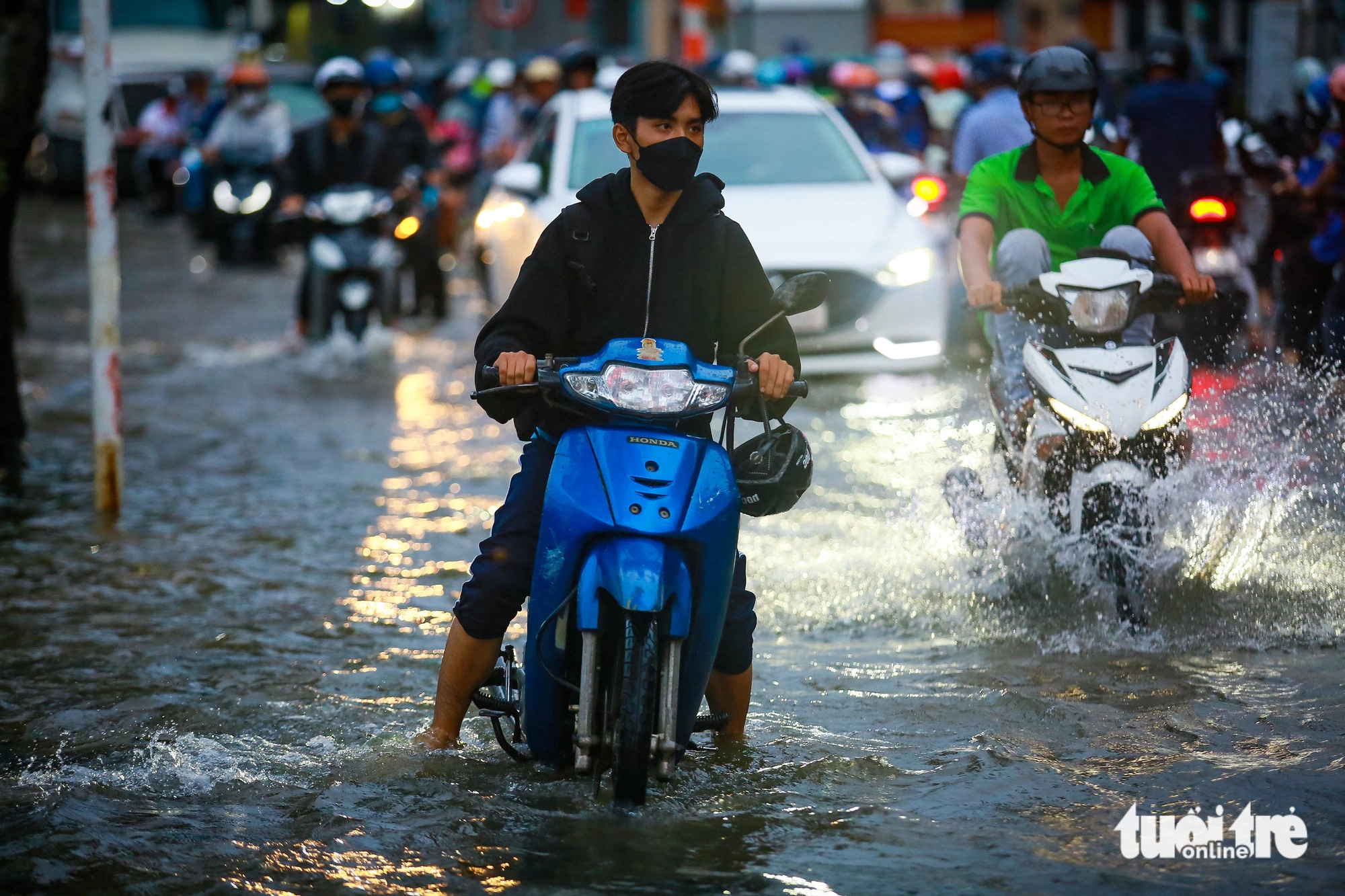 Vehicles wade through the flooded Tran Xuan Soan Street in District 7, Ho Chi Minh City during high tides, September 20, 2024. Photo: Le Phan / Tuoi Tre